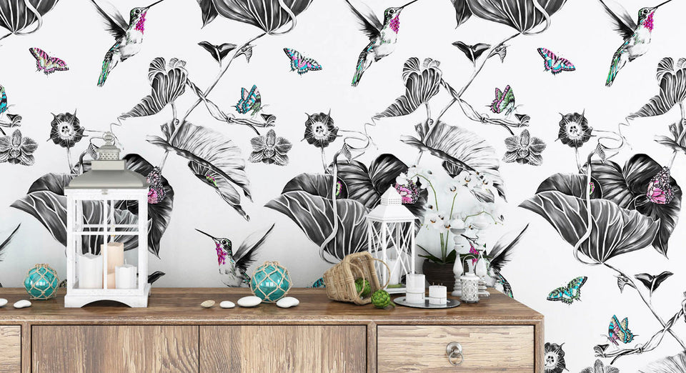 Pink hummingbird wallpaper on a wall behind and chest of drawers.