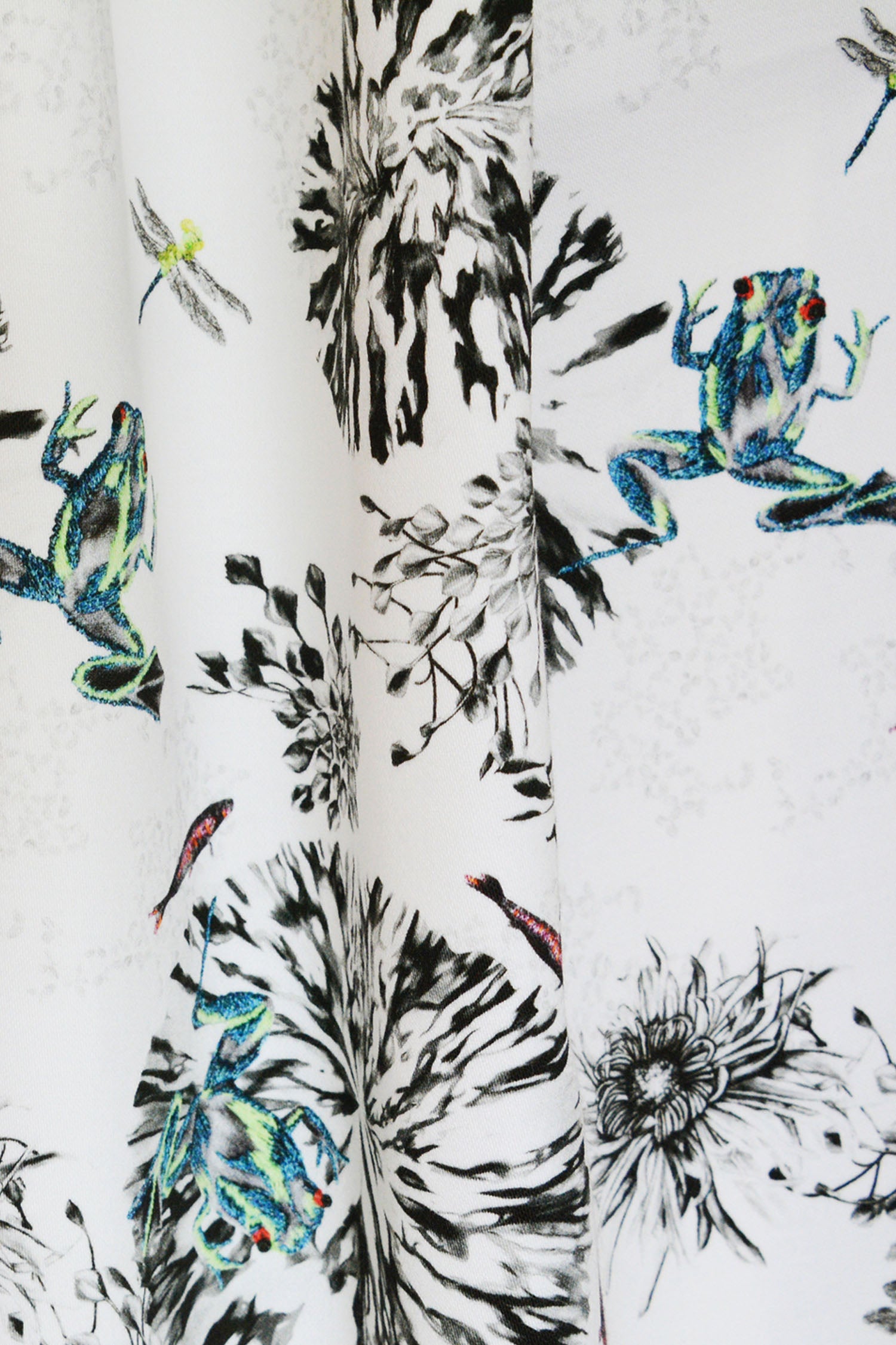 Botanical fabric with green frogs, dragon flies and fish curtains close up.