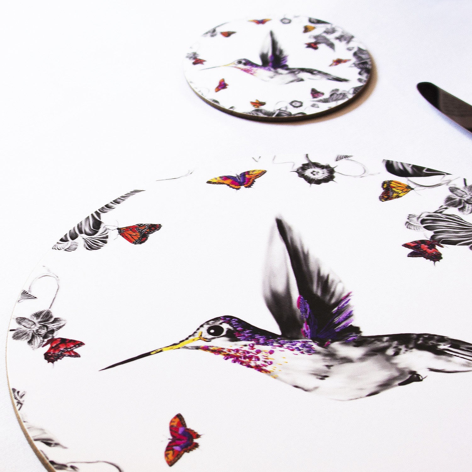 White hummingbird coaster on the table.