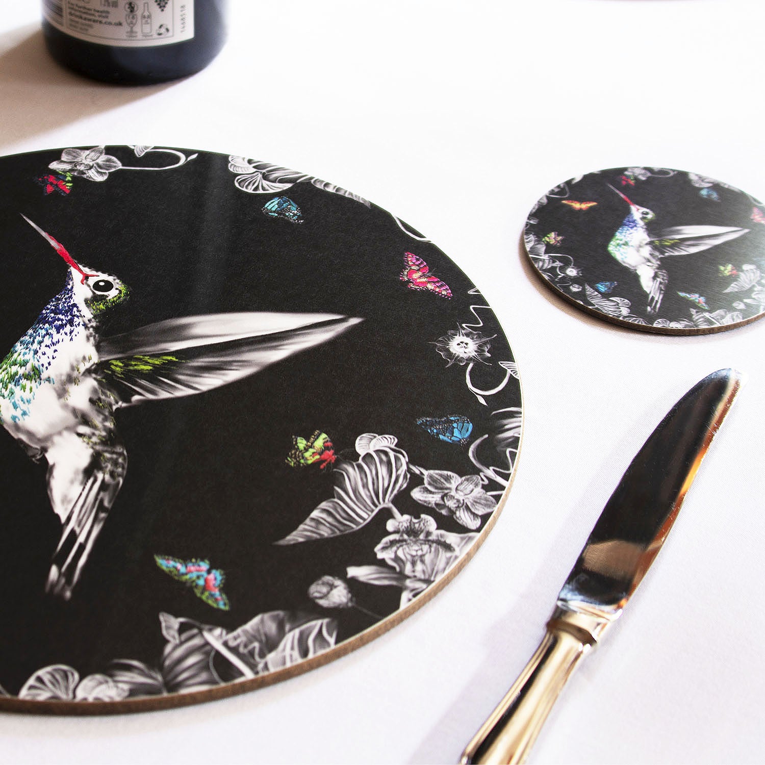 Black hummingbird coaster on the table.